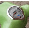 A close up of the speedometer on a green scooter.