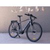 A bicycle is parked in front of a wall.