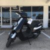 A black scooter parked in front of a store.